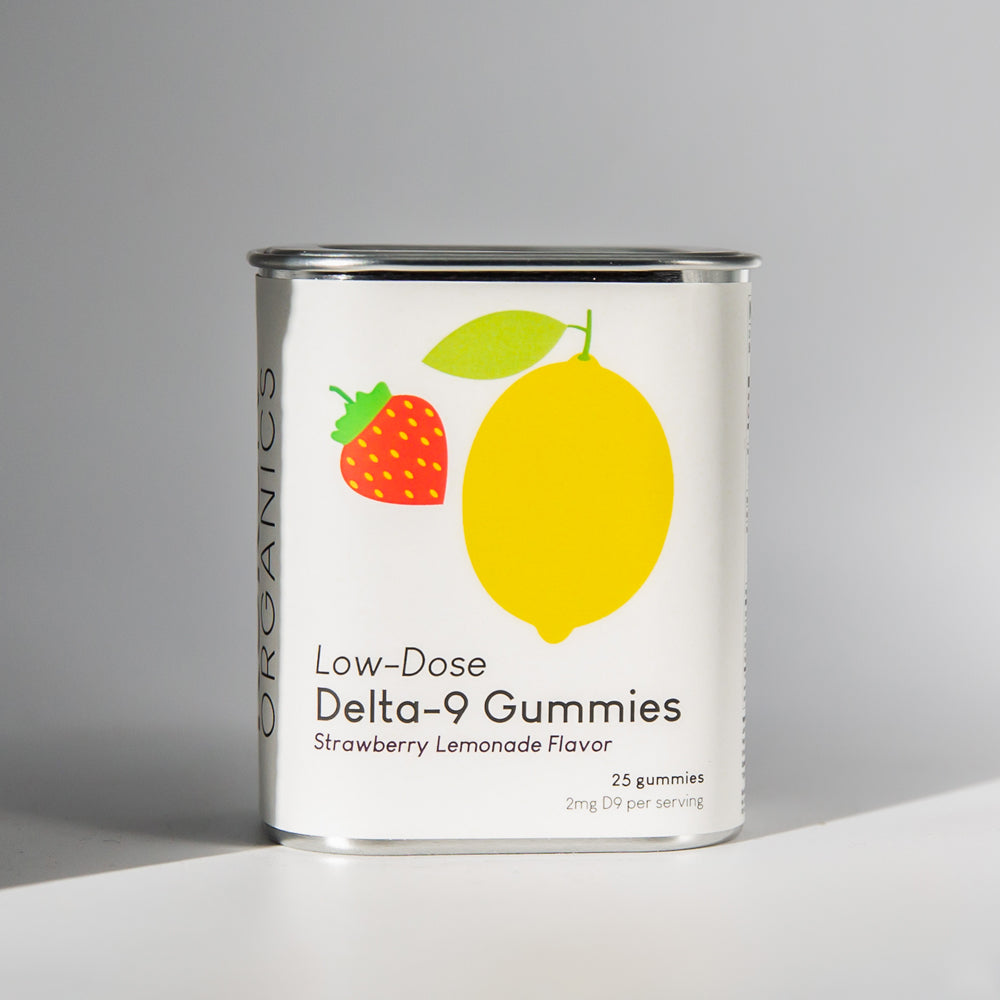Tin of Kursiv Organics gummies with a white label on shadowed white background.