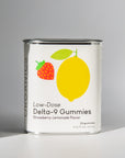 Tin of Kursiv Organics gummies with a white label on shadowed white background.